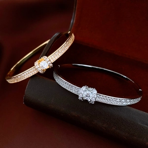 Close-up of 18K gold and silver plated bangles with pave diamonds and center stones