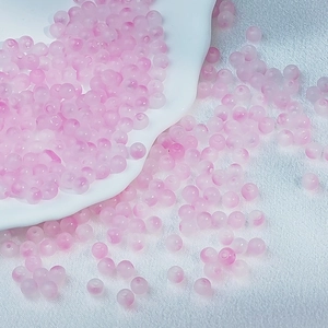 Detailed view of 6mm pink frosted glass beads on white silk for DIY jewelry making
