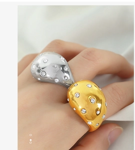 Detail of gold and silver pebble-shaped open rings with micro-set diamonds on finger