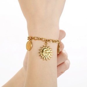 18K gold plated stainless steel bracelet with sun, moon and coin charms on a model wrist