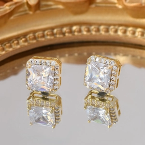 Macro detail of gold halo stud earrings with princess cut cubic zirconia and micro-pave diamonds