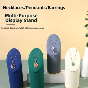 Macro view of four velvet necklace display stands in navy, emerald, gray and beige