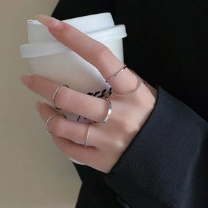 Minimalist silver rings set worn by a hand holding a coffee cup for a stylish daily look