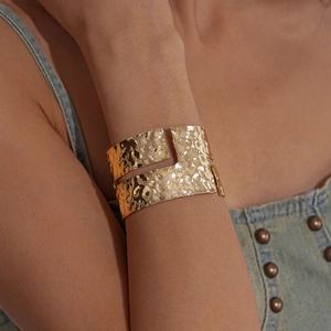 Detailed view of wide gold hammered cuff bracelet with geometric irregular textures