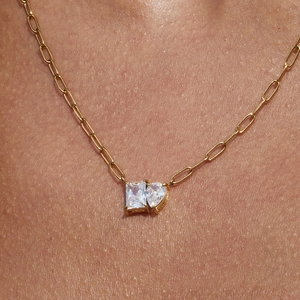 Gold paperclip chain necklace with rectangular and heart-shaped zircon pendants on model