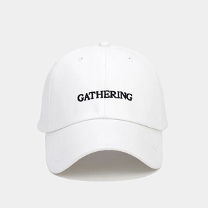Gros plan détaillé de la broderie GATHERING sur une casquette de baseball en coton blanc