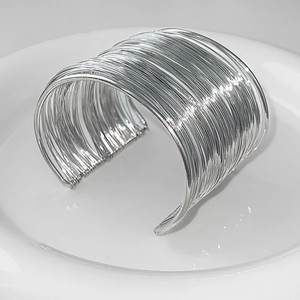 Macro shot of silver multilayer parallel wire texture on a wide open cuff bracelet