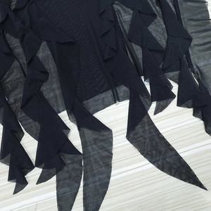 Detail view of the layered black sheer mesh and irregular hem of the summer dress
