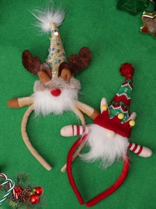 Nahaufnahme von Weihnachts-Haarreifen mit Rentier- und Zwerg-Design auf grünem Stoff