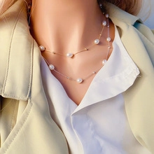 Dettaglio della collana di perle d'acqua dolce naturali a strati su una modella
