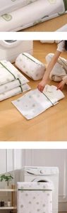 Close-up of printed mesh laundry bags with avocado patterns and durable green zippers