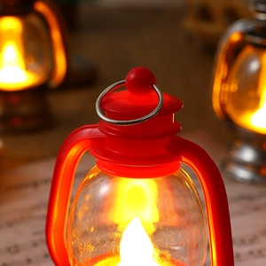 Close-up of red vintage LED lantern with warm glowing light and metal handle