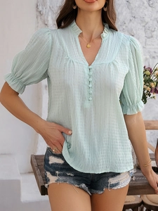 Detail of light blue V-neck top with pleated texture and ruffle flare sleeve accents