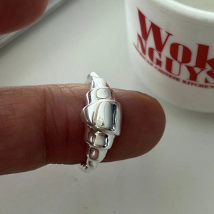 Detail of 925 sterling silver croissant ring featuring modern polished ripple texture