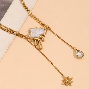 Macro view of 18K gold-plated Y-necklace with cloud pendant and tassel star charms
