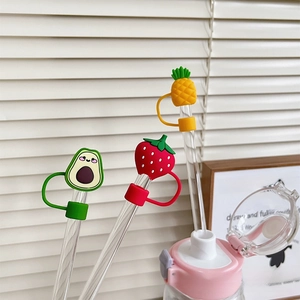 Detailed view of silicone cartoon fruit straw covers in avocado, strawberry and pineapple shapes