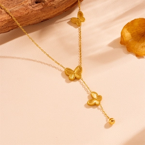 Detailed view of golden butterfly pendant with textured wings and small steel beads