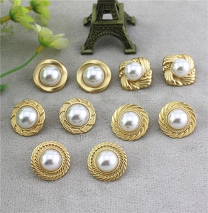 Détail de boutons vintage dorés avec perles incrustées et divers motifs rétro chic