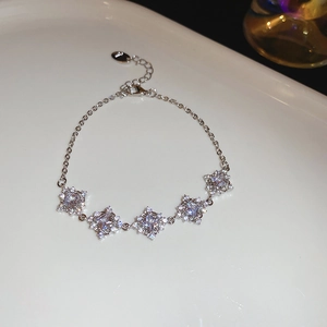 Detail of silver S925 bracelet with five sparkling diamond-cut cubic zirconia stones