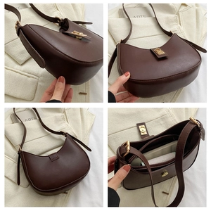 Vue détaillée du sac croissant marron foncé avec boucle dorée et poche intérieure zippée