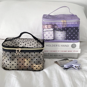 Mesh makeup bags with heart patterns and gold star zipper charms in black and purple