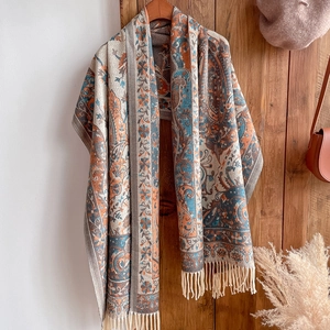 Detail of bohemian shawl with paisley patterns, fringes, and retro ethnic color scheme