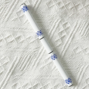 Dual-use nail art brush tool with white and blue porcelain pattern on fabric background