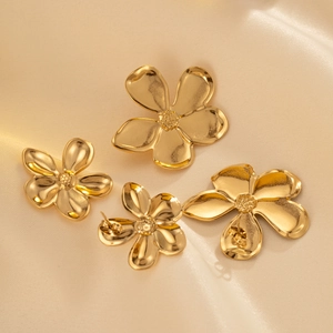 French vintage gold-plated floral stud earrings on champagne silk background