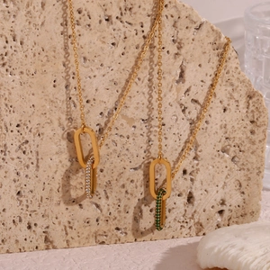 Detail view of gold interlocked rings necklace with green and white zircon inlays