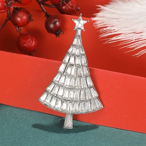 Close-up of a silver Christmas tree brooch with rhinestones on a festive red box