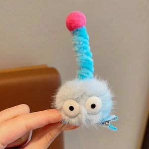 Détail de la pince à cheveux en peluche bleue avec yeux de dessin animé pour enfant