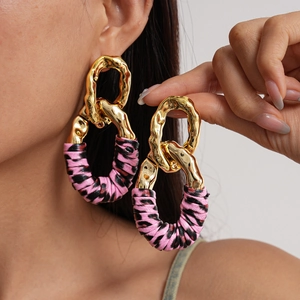 Exaggerated geometric gold metal and pink leather hoop earrings for women on model