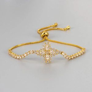 Detail of adjustable gold slider bracelet with a sparkling zircon floral clover pendant