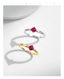 Macro shot of silver and gold rings with square-cut ruby red stones and claw settings