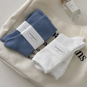 Minimalist vertical ribbed crew socks in creamy white and denim blue on canvas bag