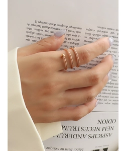 Detailed close-up of a rose gold spiral twist ring featuring a delicate beaded end