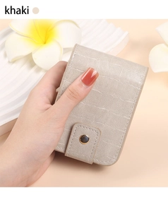 Detail of khaki crocodile pattern leather lipstick pouch with mirror and gold magnetic clasp
