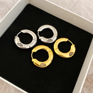 Detailed view of gold and silver plated hoop earrings with drop-shaped zircon stones