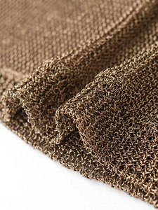 Gros plan sur la texture du tissu en maille tricotée bronze métallisé et motif fin