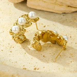 Golden C-shaped wavy stainless steel earrings with three round white pearls on stone base