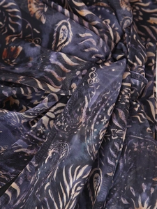 Vue macro détaillée du tissu en maille bleu foncé avec motifs paisley et plumes dorés