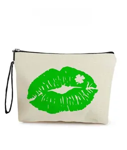 Detail of canvas makeup bag featuring green lip print with a clover on white background