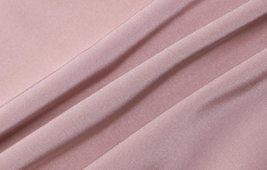 Dettaglio del tessuto in raso rosa con pieghe eleganti sull'abito schiena scoperta