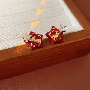 Gold plated red enamel star earrings with zircon inlay in a wooden jewelry box
