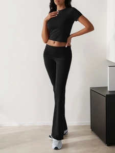 Detail of black slim short sleeve top and high waist flare pants loungewear set