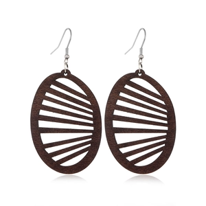 Detail of dark brown hollow oval wooden earrings with metallic silver ear hooks