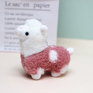 Dettaglio di un ciondolo a forma di alpaca in peluche rosa e bianco in lana di agnello