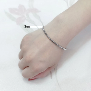 Detail of a 3mm silver beaded stainless steel bracelet shown worn on a wrist