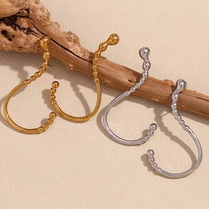 Modern fluid 18K gold and silver stainless steel question mark ear cuffs on wood