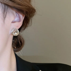 Detailansicht eines eleganten Gold-Perlenohrsteckers mit Strass auf Modell